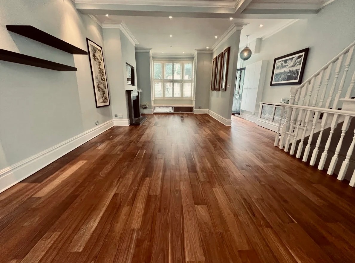 Wide-angle of a restored walnut plank living room in Eltham with satin-finished Hardwood Floors.