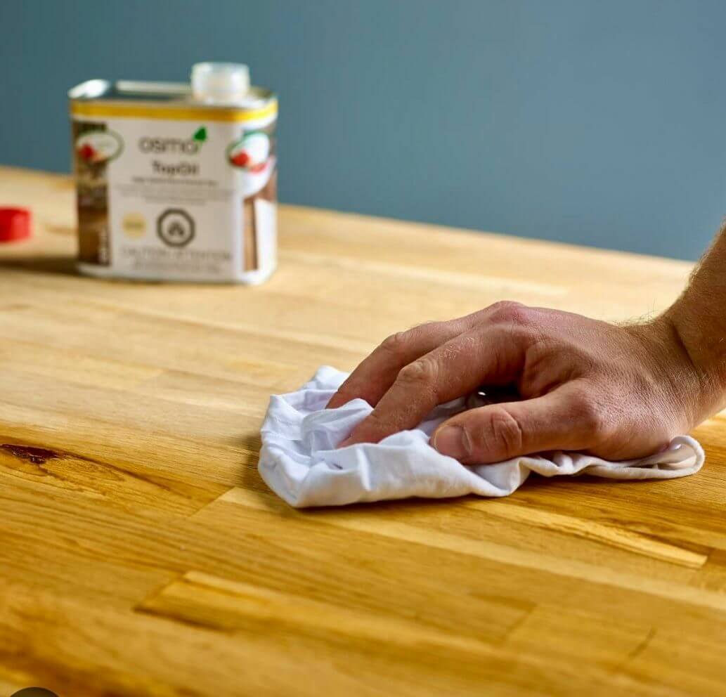 Worktop refinishing in Eltham with oil being applied to a solid oak butcher block kitchen worktop for a smooth, hygienic finish.