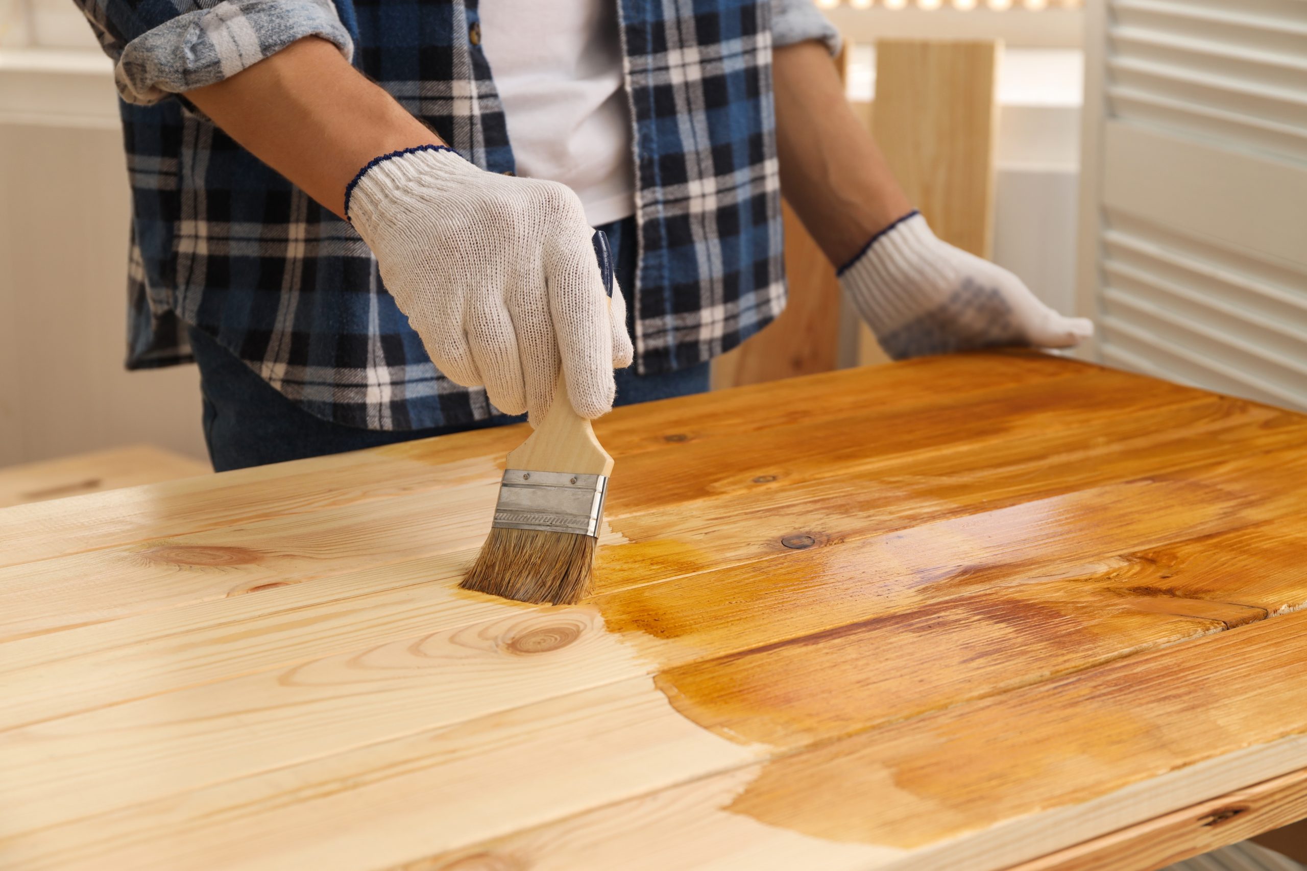 Worktop Refinishing in Eltham with protective oil being brushed onto a solid pine softwood kitchen worktop to restore a warm, durable surface.